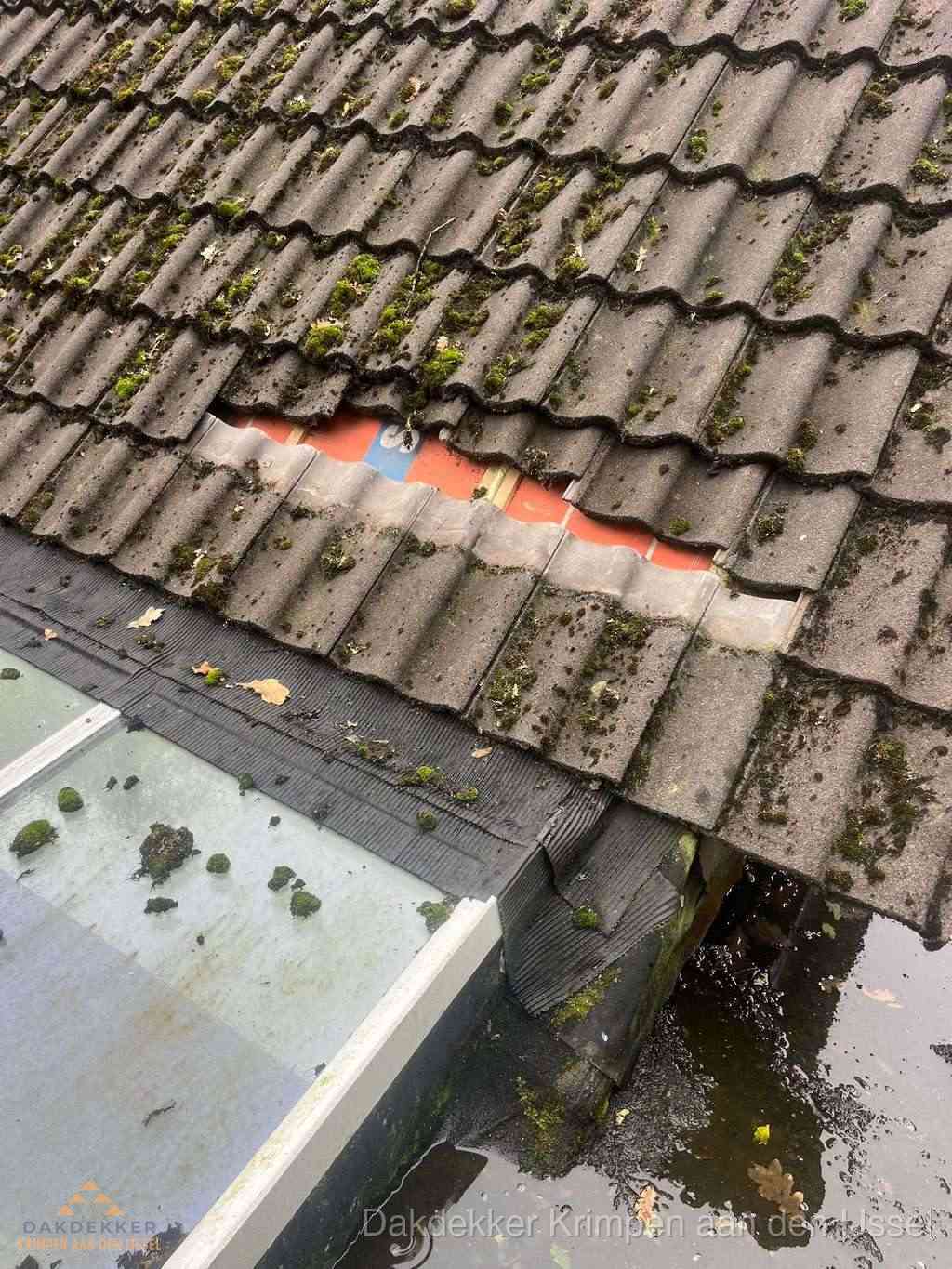 Beschadigd pannendak met ontbrekende dakpannen voor reparatie in Krimpen aan den IJssel