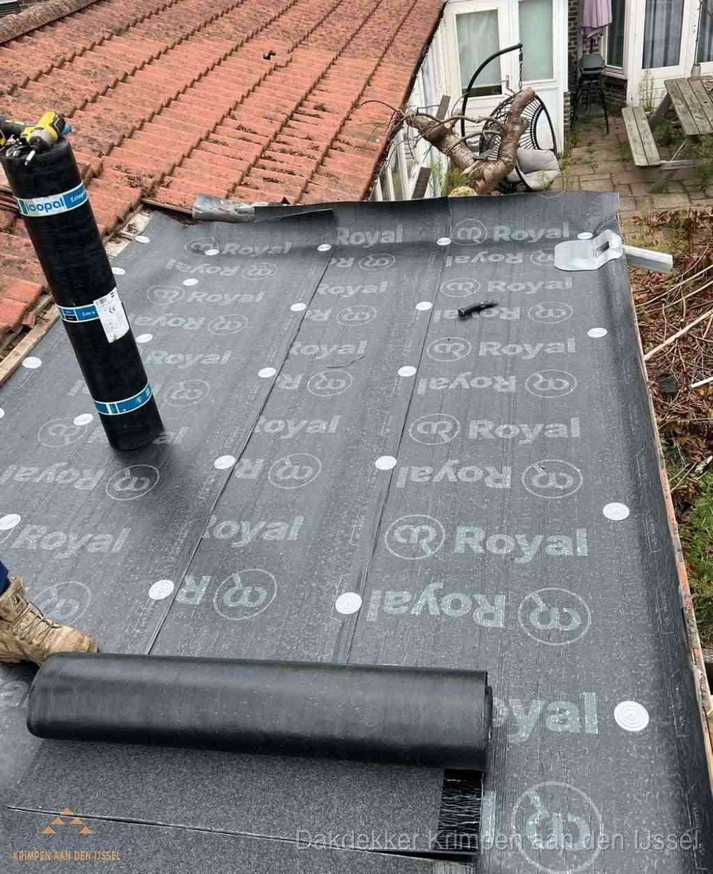 Plat dak met nieuwe bitumen dakbedekking en brandgereedschap in Krimpen aan den IJssel