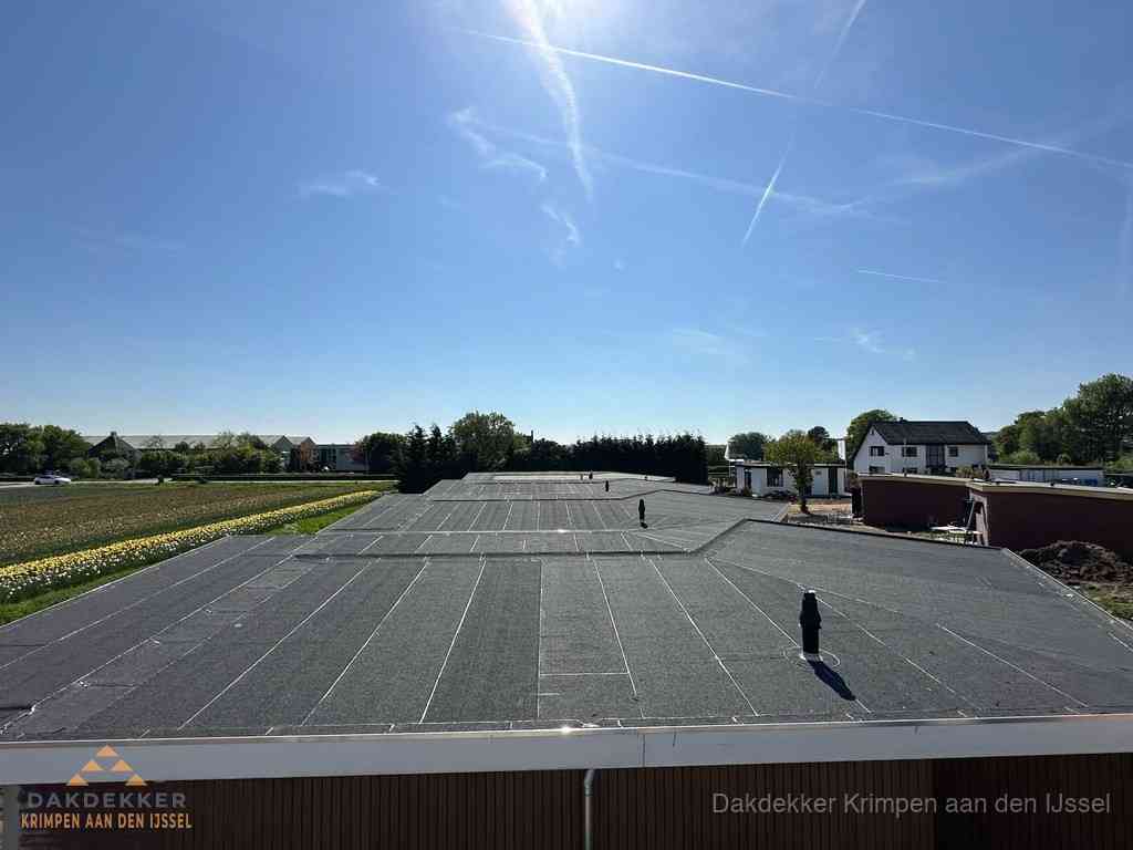 Groot plat dak met bitumen dakbedekking op bedrijfspand in Krimpen aan den IJssel