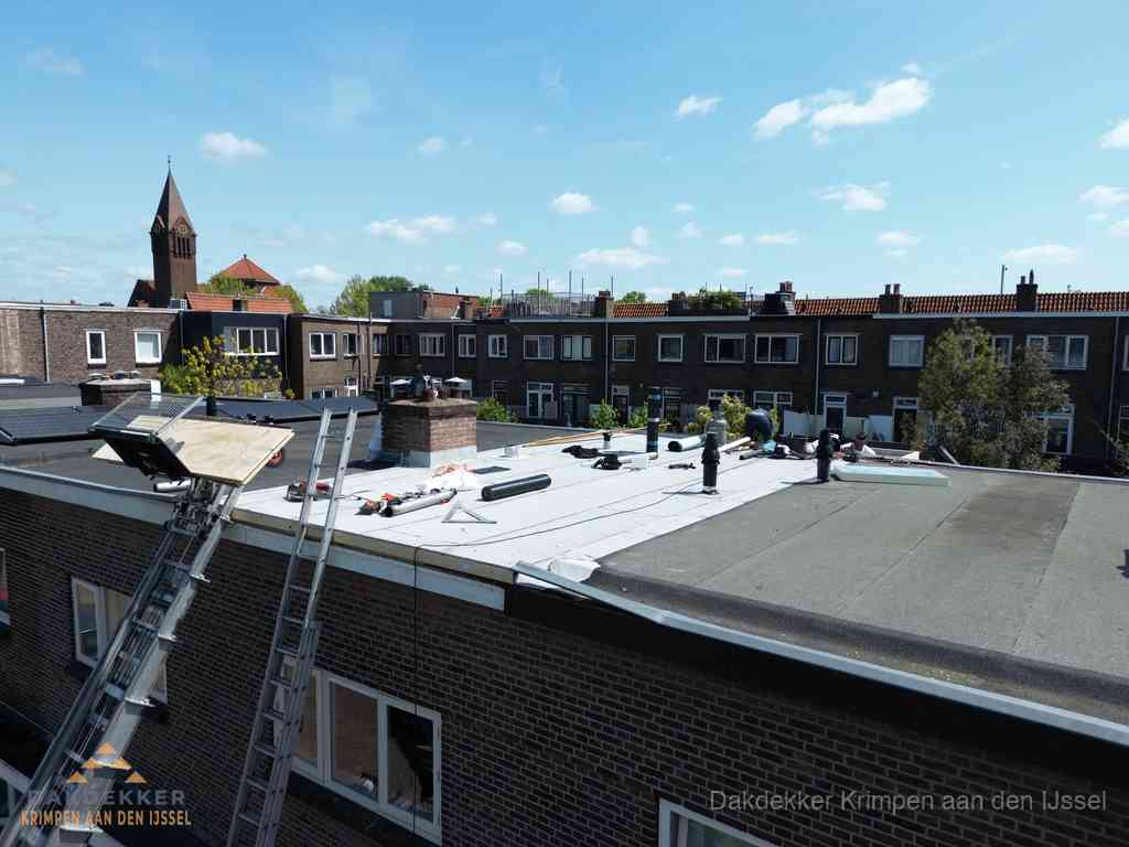 Dakdekkers aan het werk op plat dak in Krimpen aan den IJssel