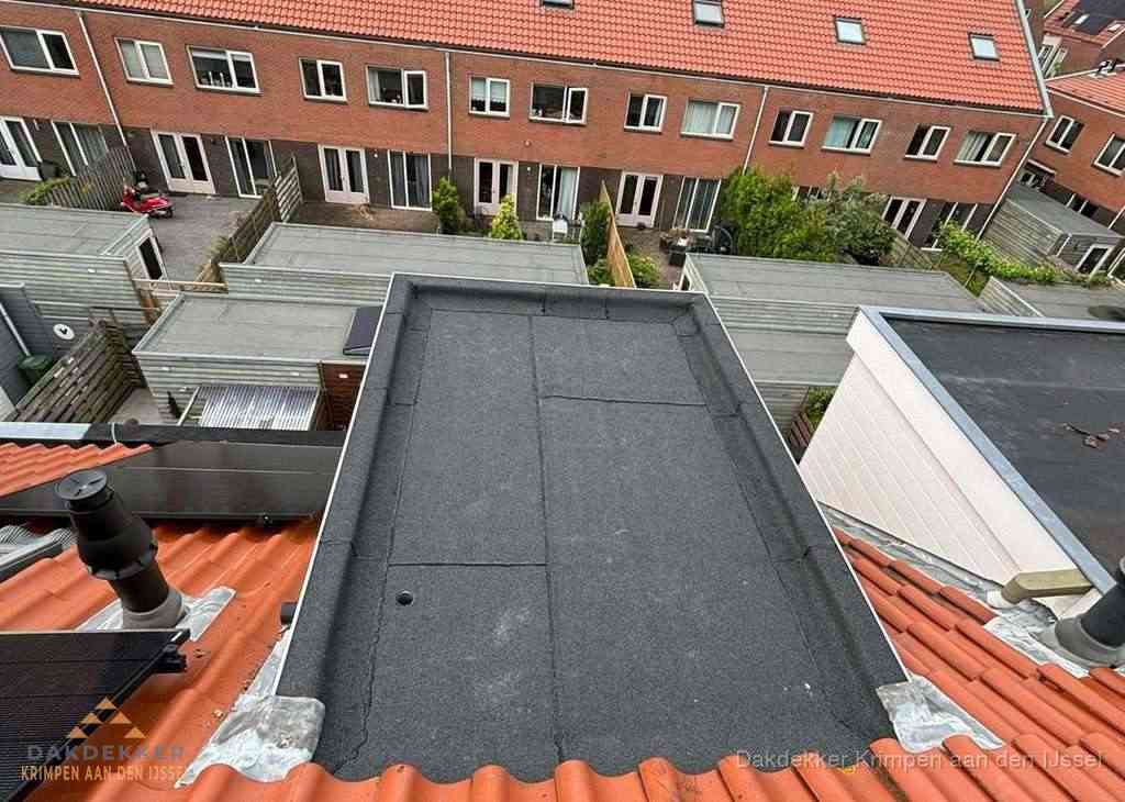 Plat dak met bitumen bedekking naast dakkapel in Krimpen aan den IJssel