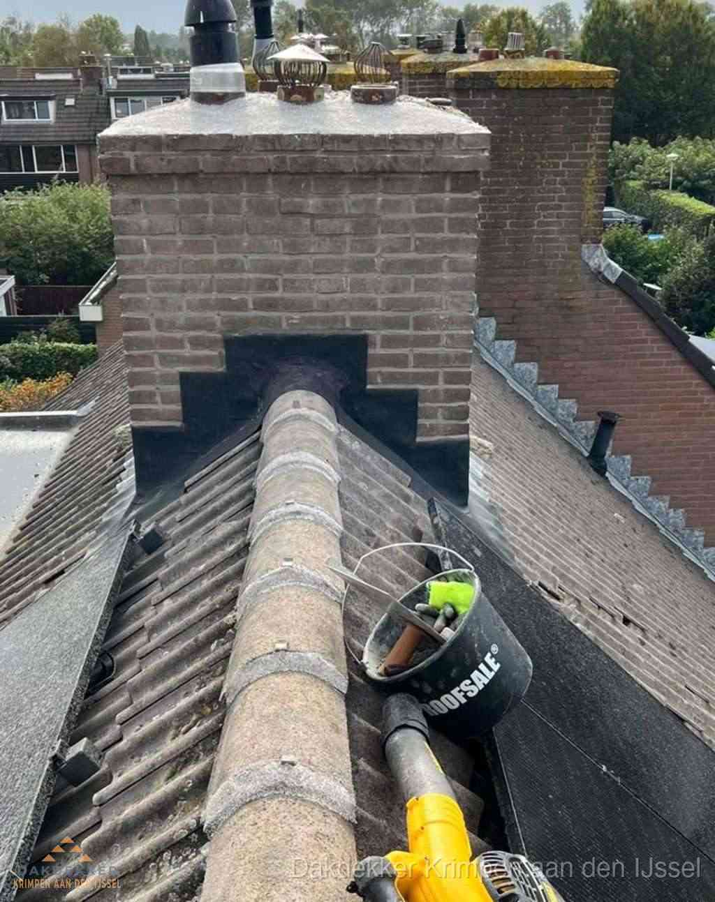 Dakdekker repareert bitumen dakleer bij dakdoorvoer in Krimpen aan den IJssel