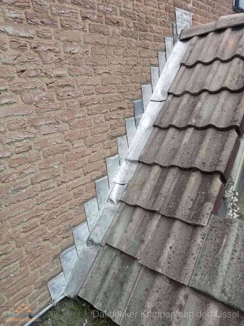 Loodslabben langs dakaansluiting bij bakstenen muur in Krimpen aan den IJssel